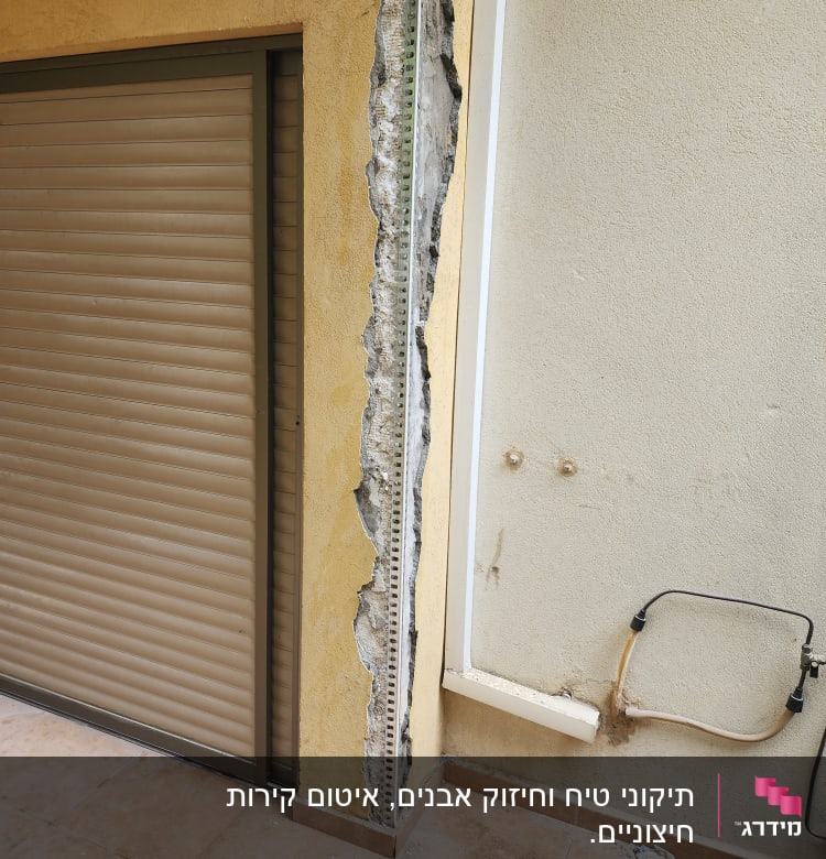 קיר עם טיח חשוף ותעלות חשמל במהלך שיפוץ